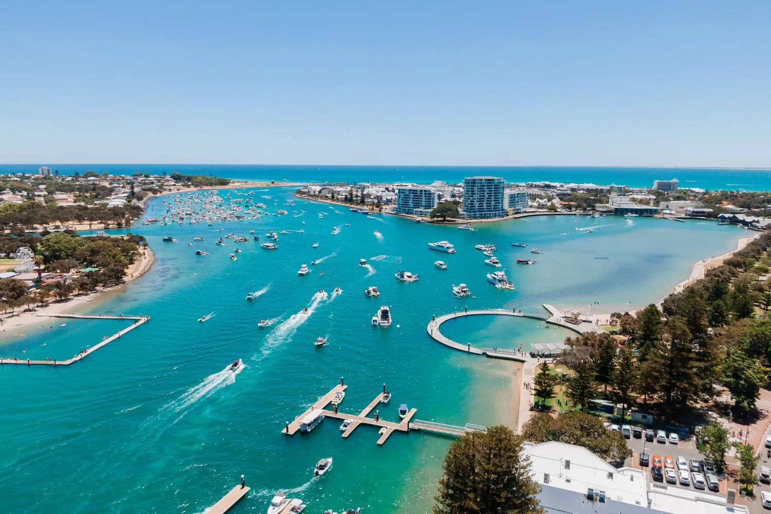 Aerial view of the Mandurah estuary with boats, jetties, and surrounding shoreline